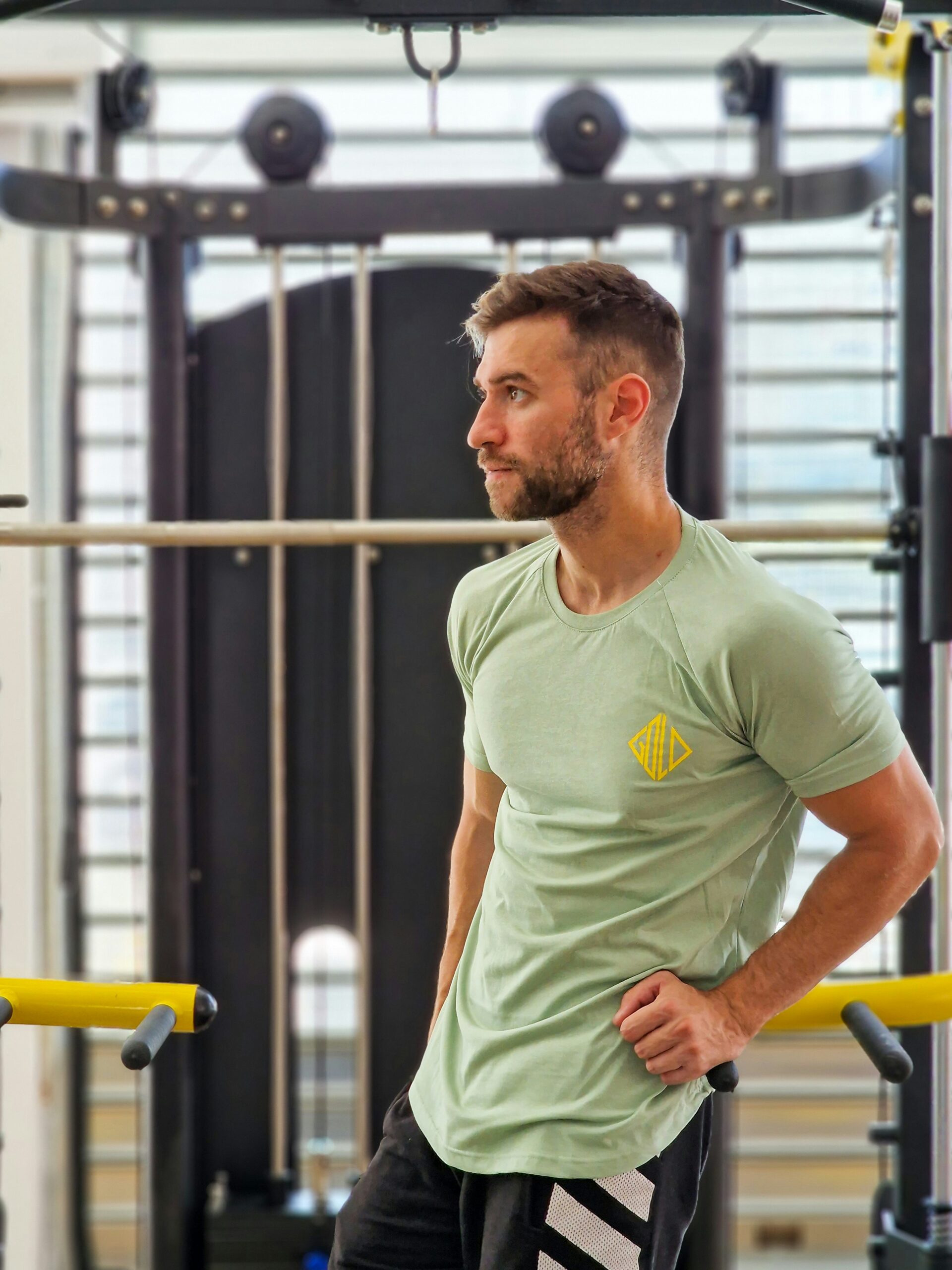 a man standing in a gym with his hands on his hips